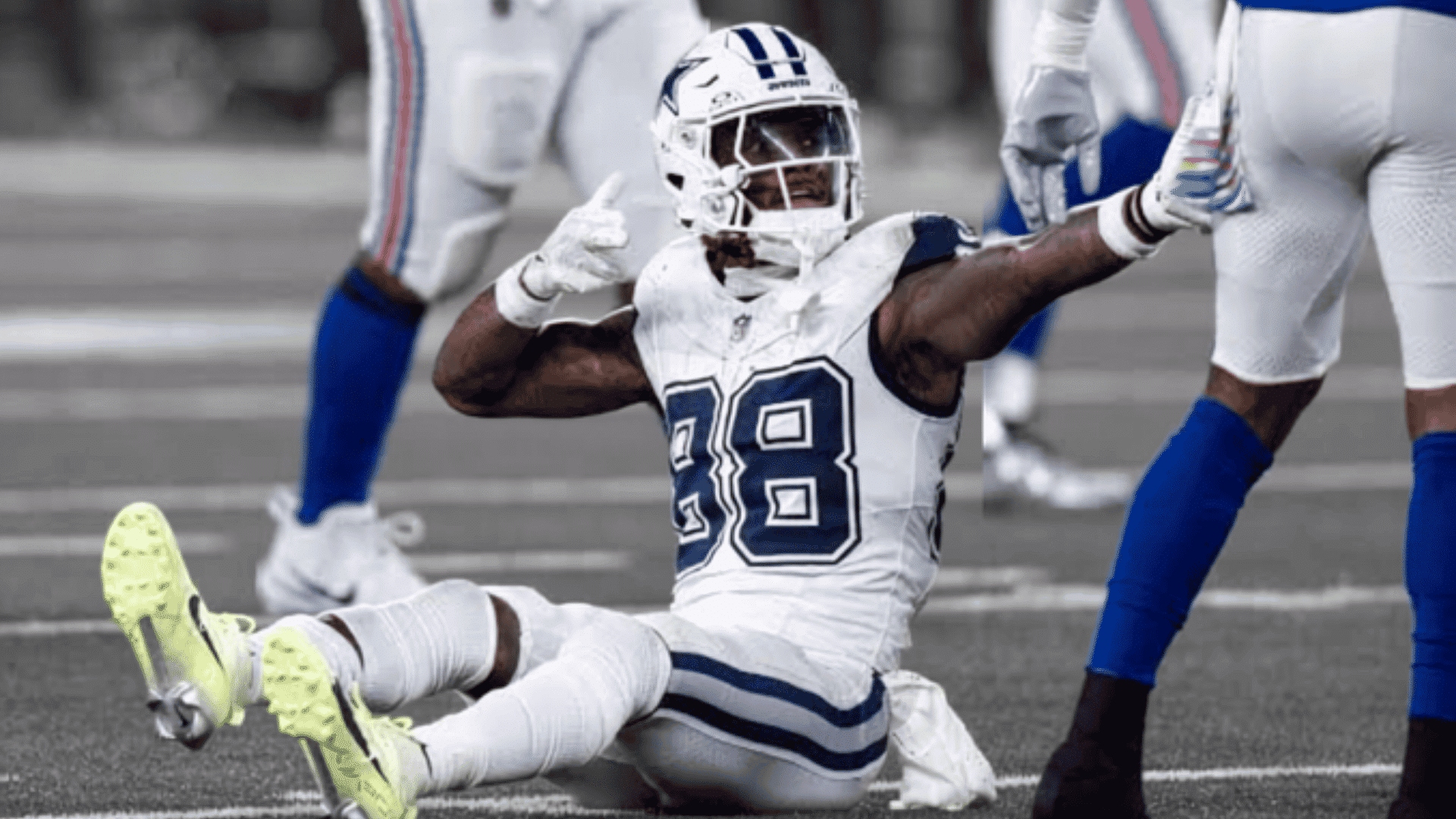 dallas cowboys receiver sitting on the field and celebrating after a play
