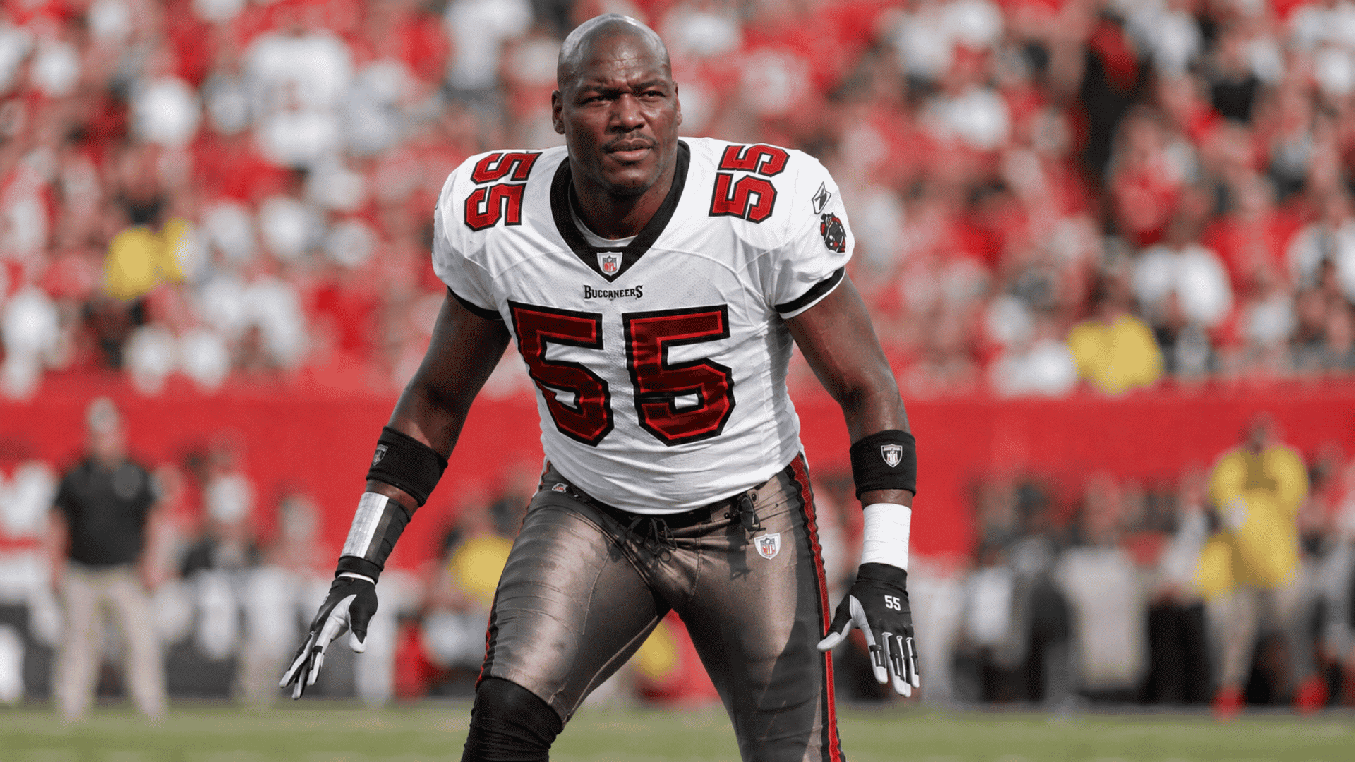 derrick brooks in a white tampa bay buccaneers jersey moving forward on the field during game action