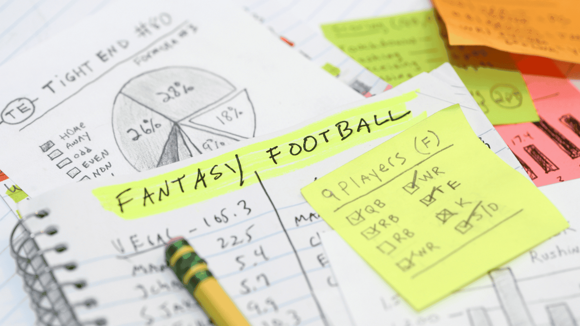 fantasy football notes with player checklist stats and strategy written across notebooks and sticky notes