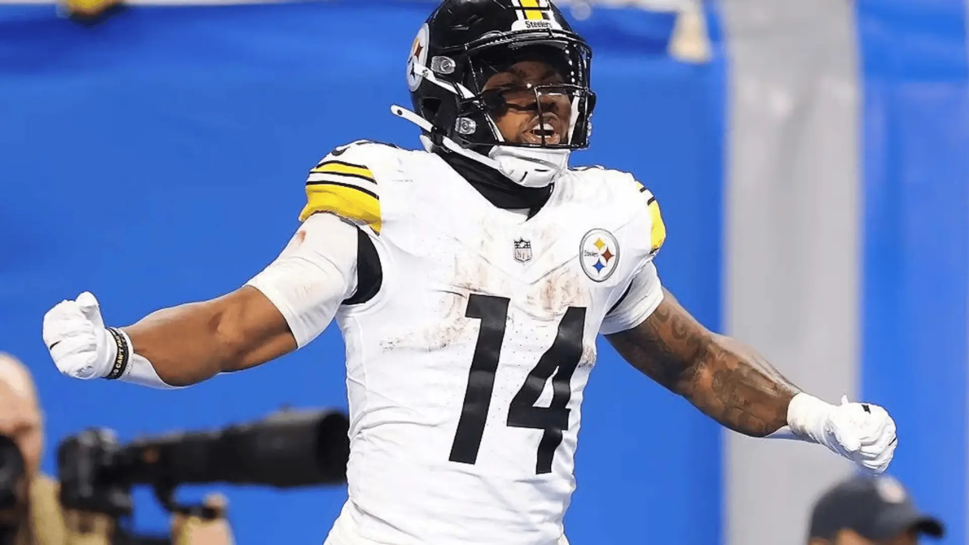 pittsburgh football player in white number fourteen uniform celebrating with arms spread