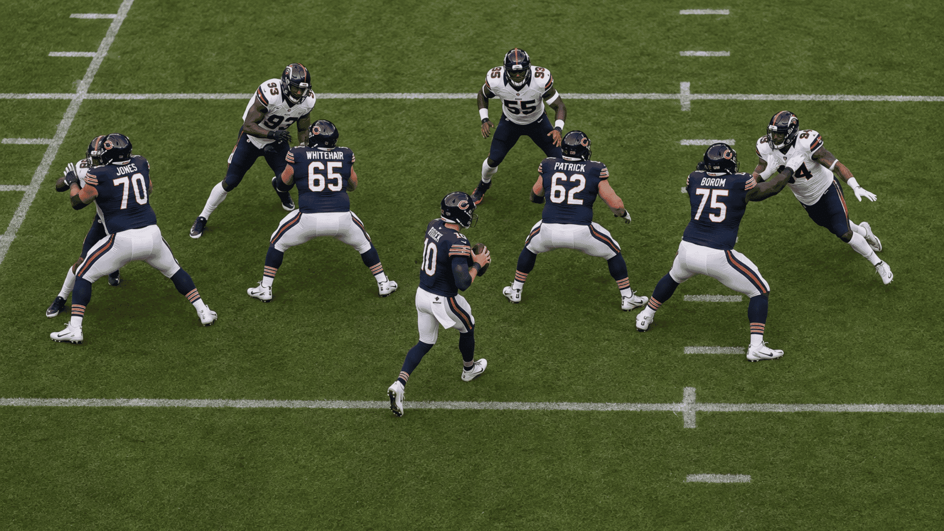 quarterback sliding inside the passing pocket while offensive linemen block rushing defenders