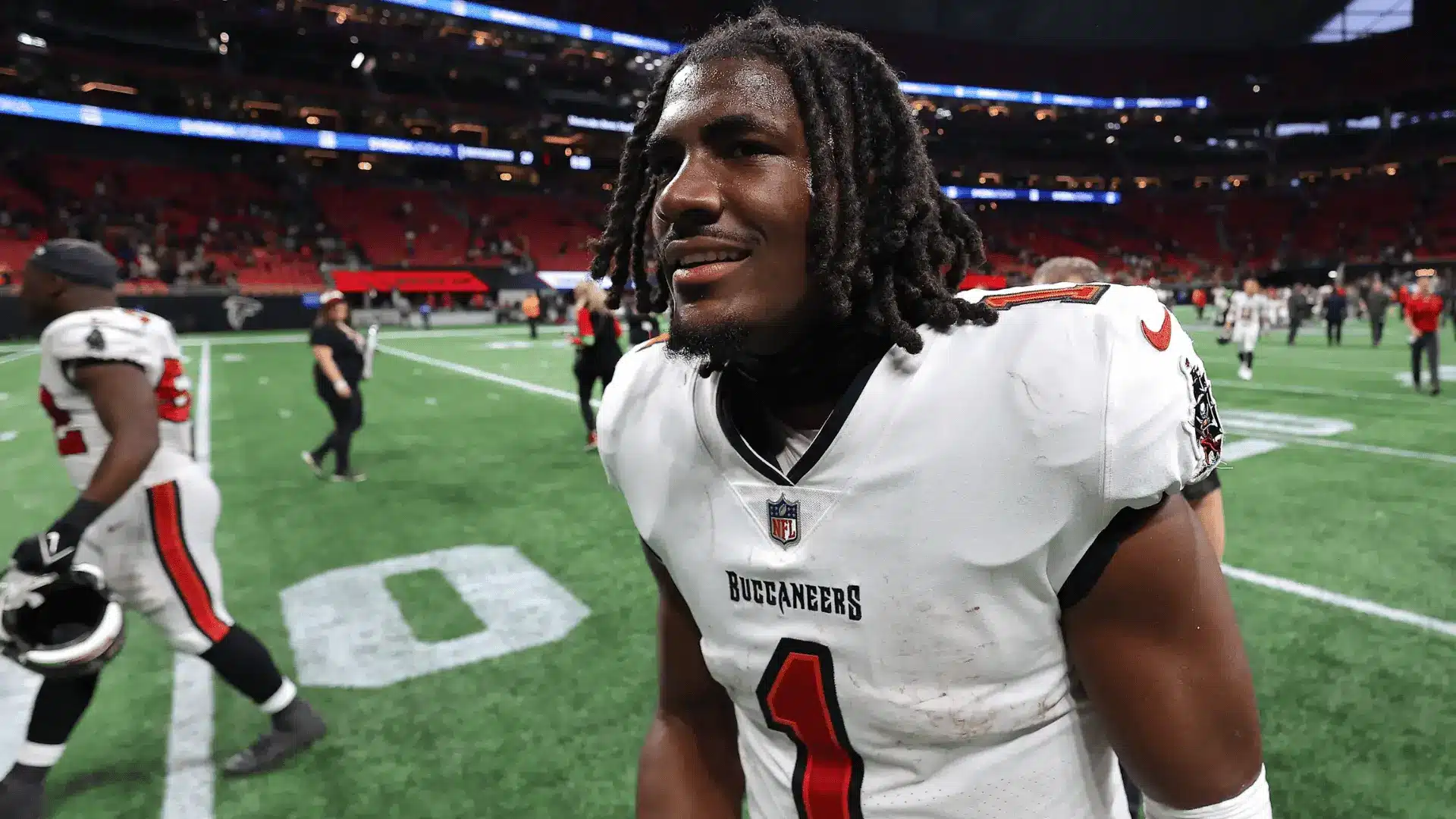 tampa bay football player in white number one uniform speaking on the field after a game