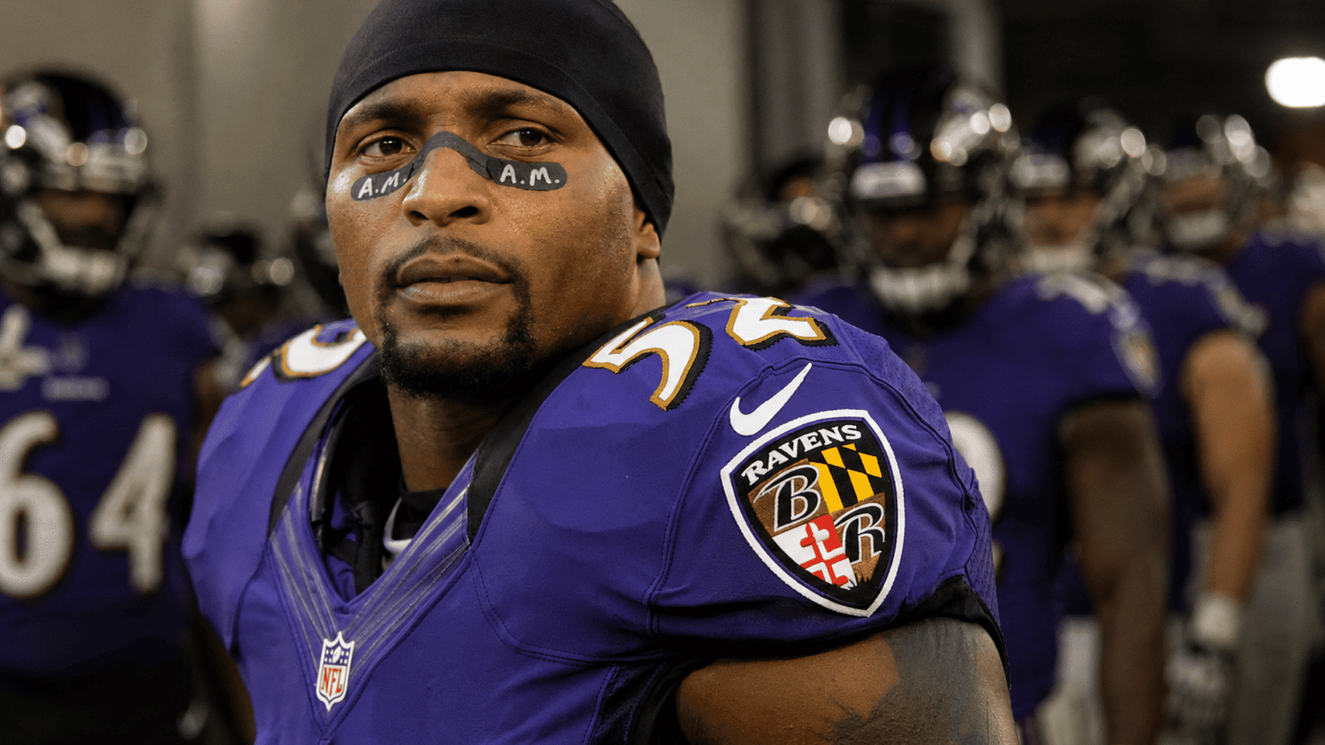 ray lewis in purple football uniform standing in a tunnel with teammates waiting behind him