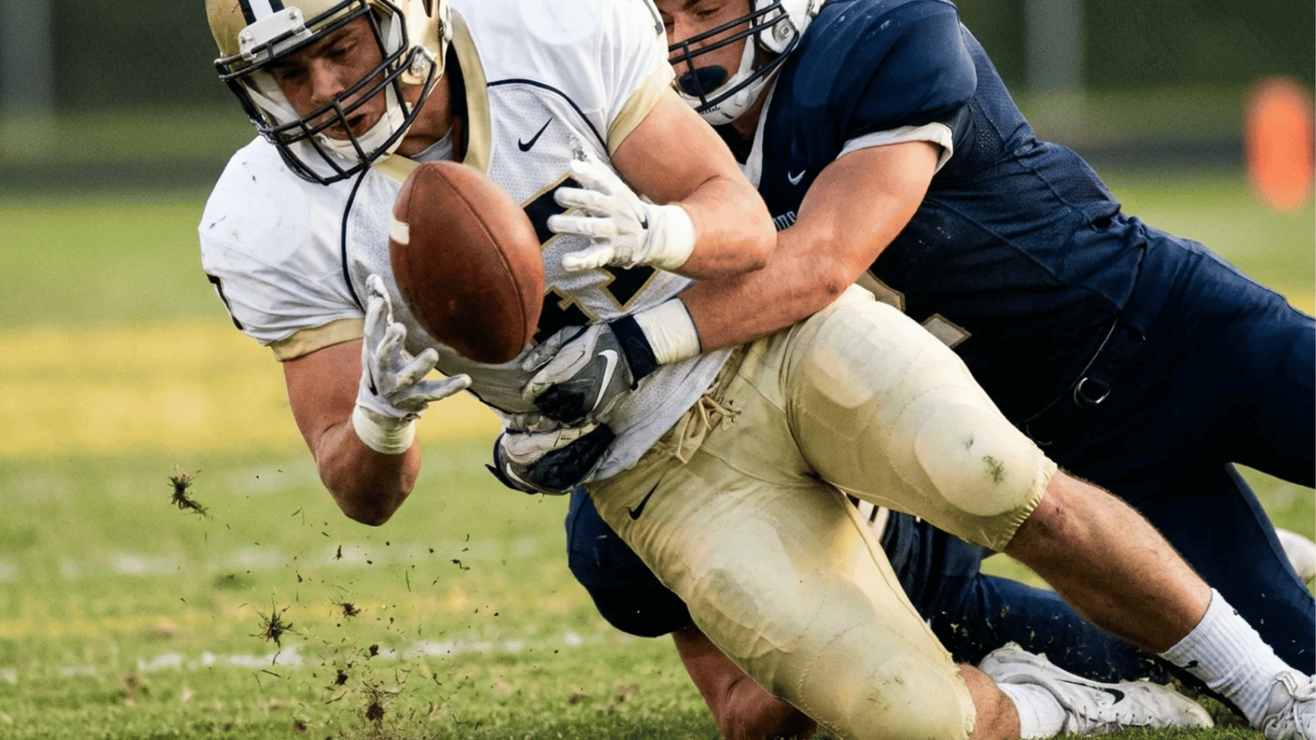 football ball carrier loses possession before being down while a defender completes the tackle
